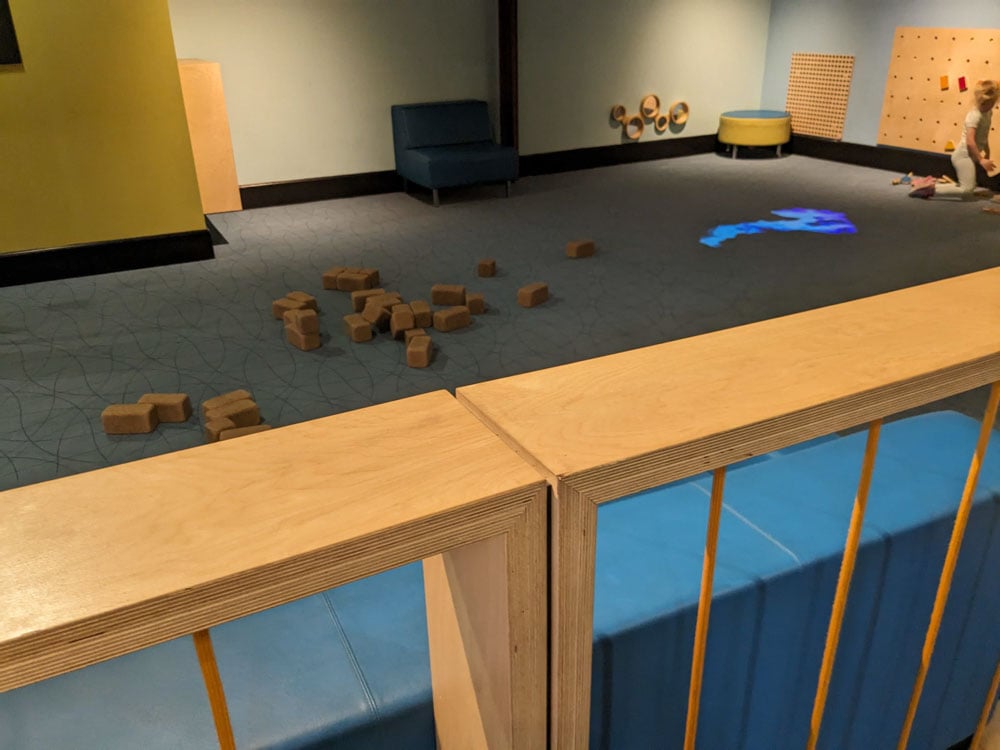 Wooden fenced off indoor play area. Lots of blocks for playing in the centre