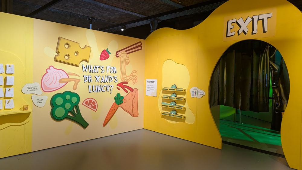 Yellow wall with exit sign and lots of illustrations on the wall