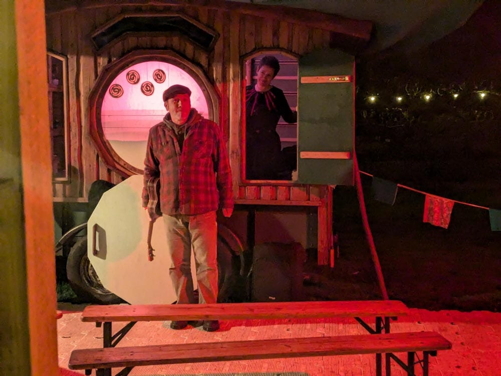 Puppeteer in front of a wooden hut