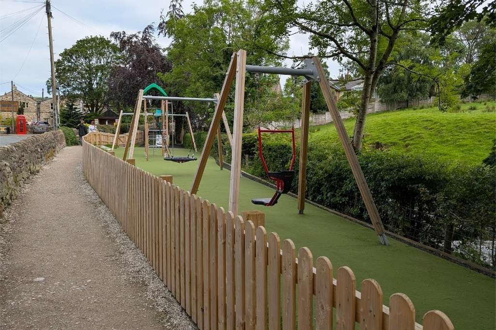 Wooden swings in a narrow play area