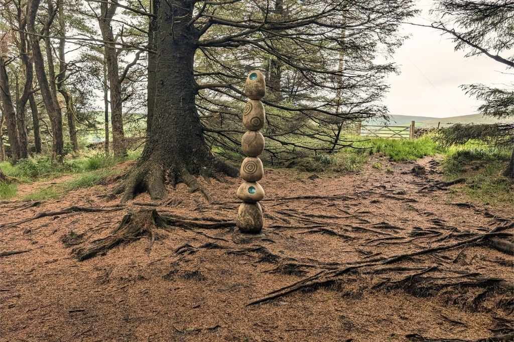 Wooden ball sculptures stacked up in the woods