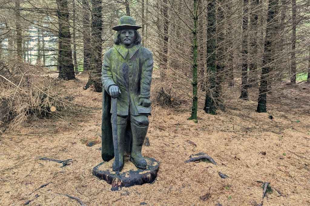 Statute of a historical wooden figure in the woods