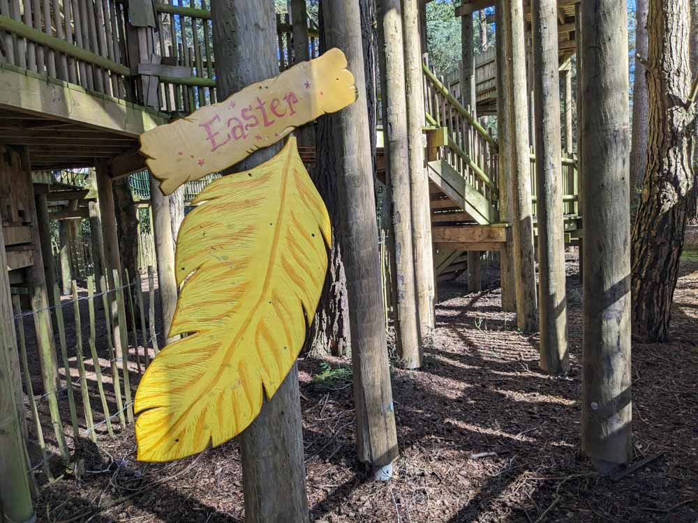 Large wooden yellow feather on a wooden play frame