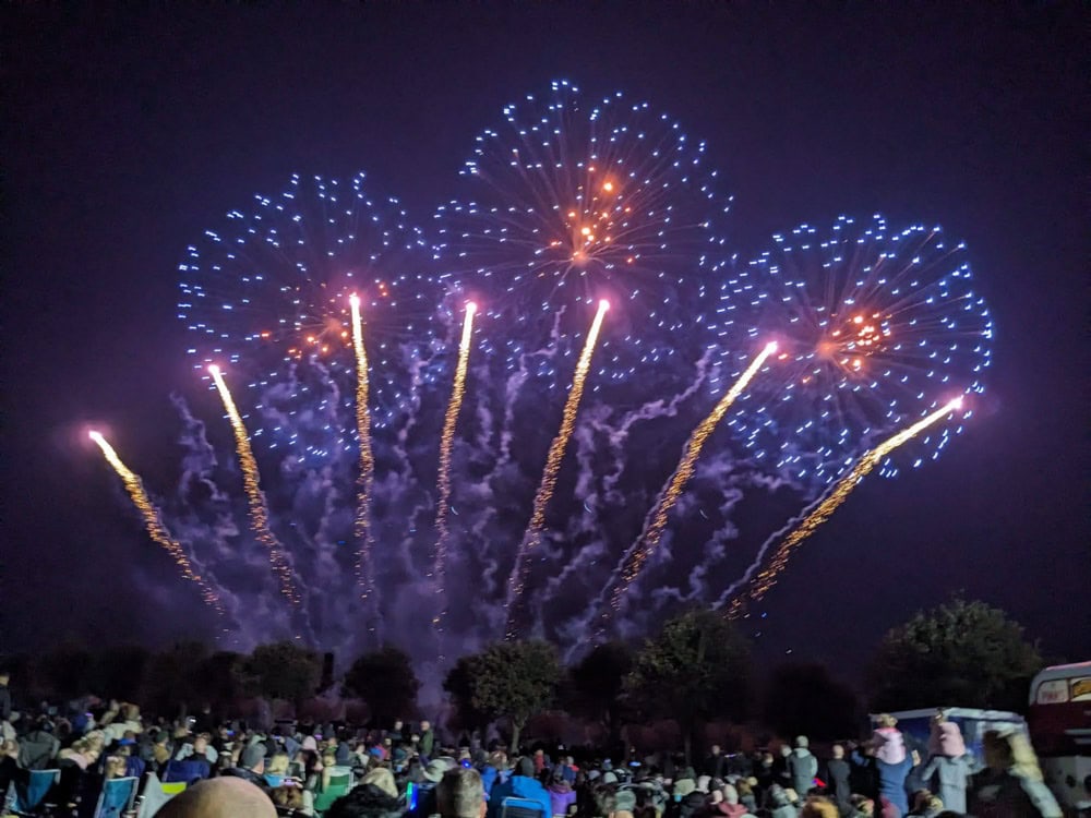 Large blue fireworks over a crowd