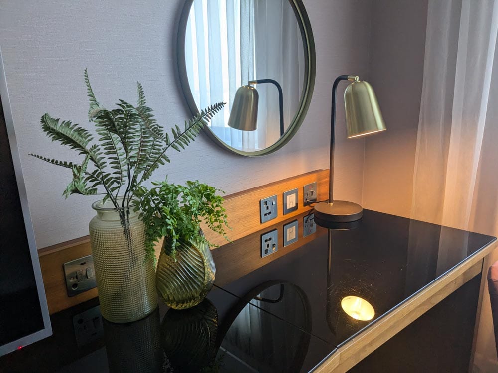 Desk area with vase of greenery