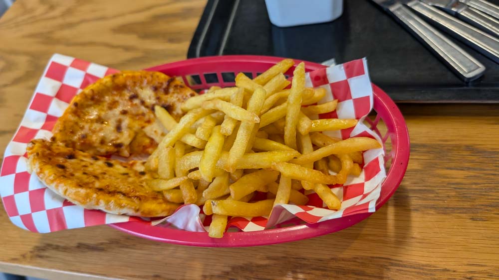 Basket of ships and a mini pizza on a table