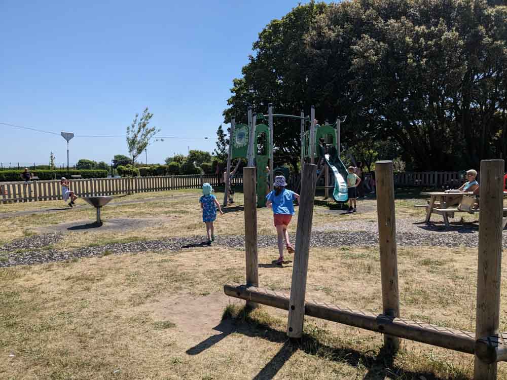 Children running towards a climbing frame and slide