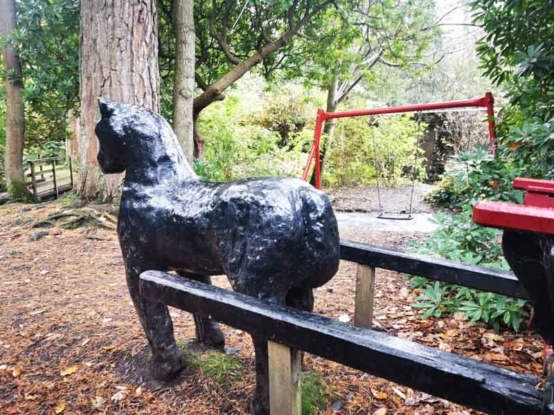 Black metal horse sculpture in the woods