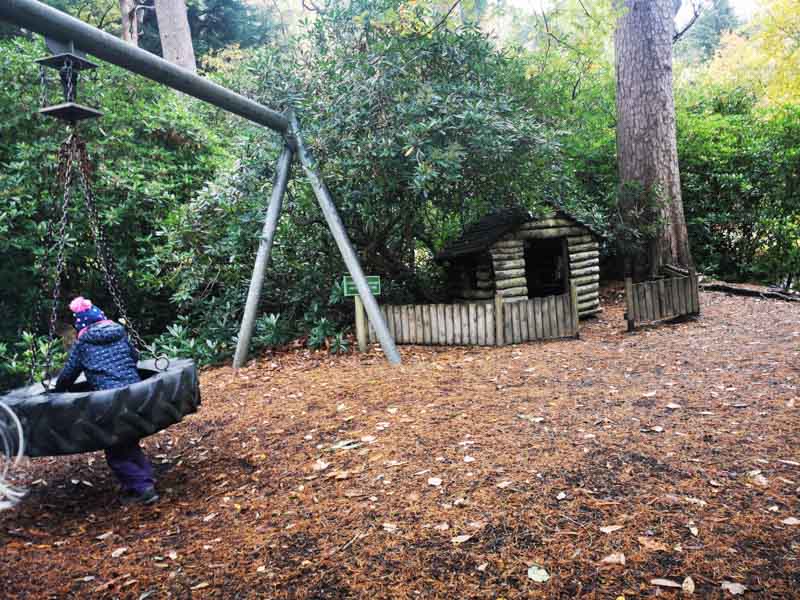 Tire swing and wooden house in woodland playground