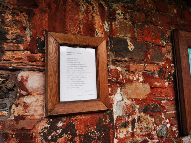 Poem in a frame on a brick wall