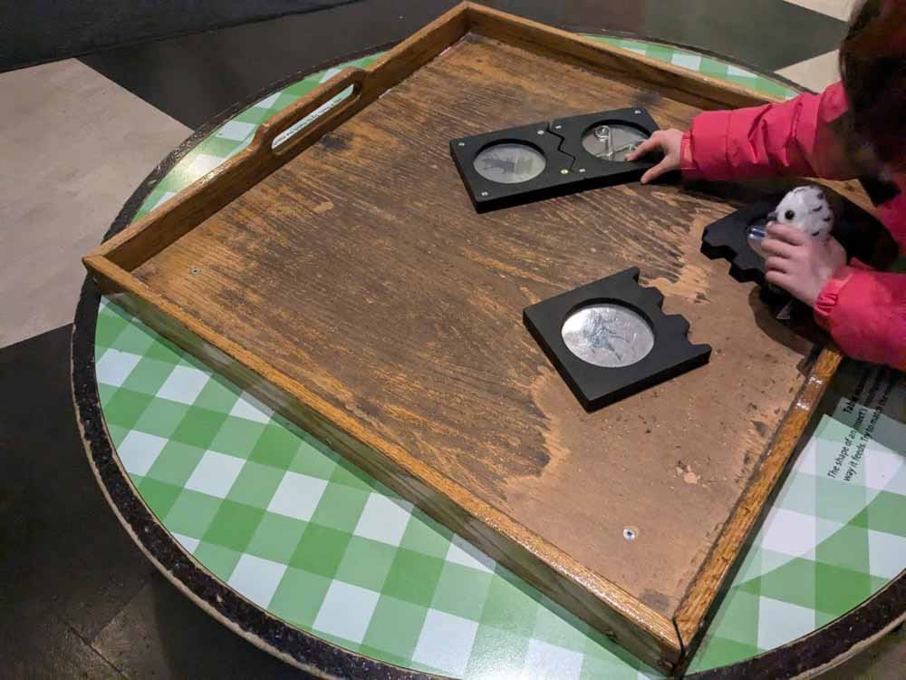 Childs hands with some puzzle pieces in black with glass circles in the centre