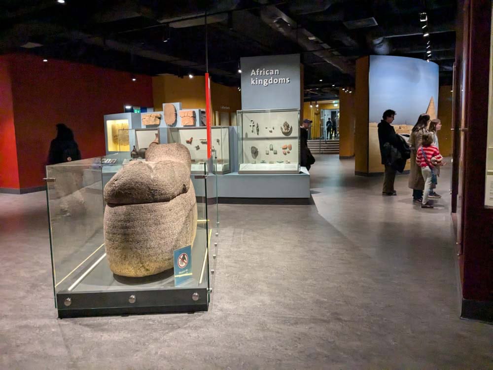Large gallery with a mummy tomb in a glass box in the centre