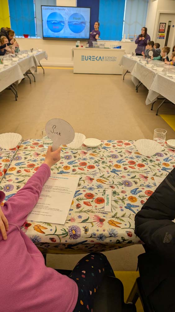 table with science kit and a child sat at it