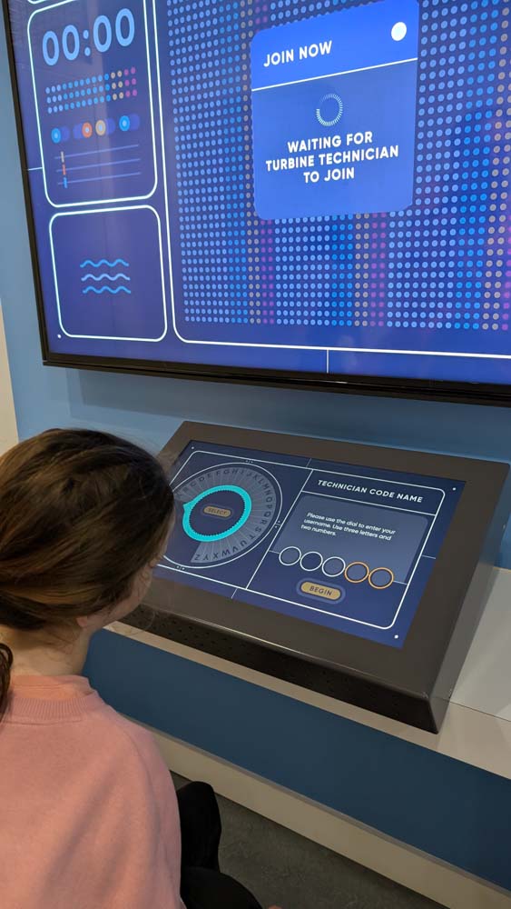 Child sat at a screen with interactive wind turbine