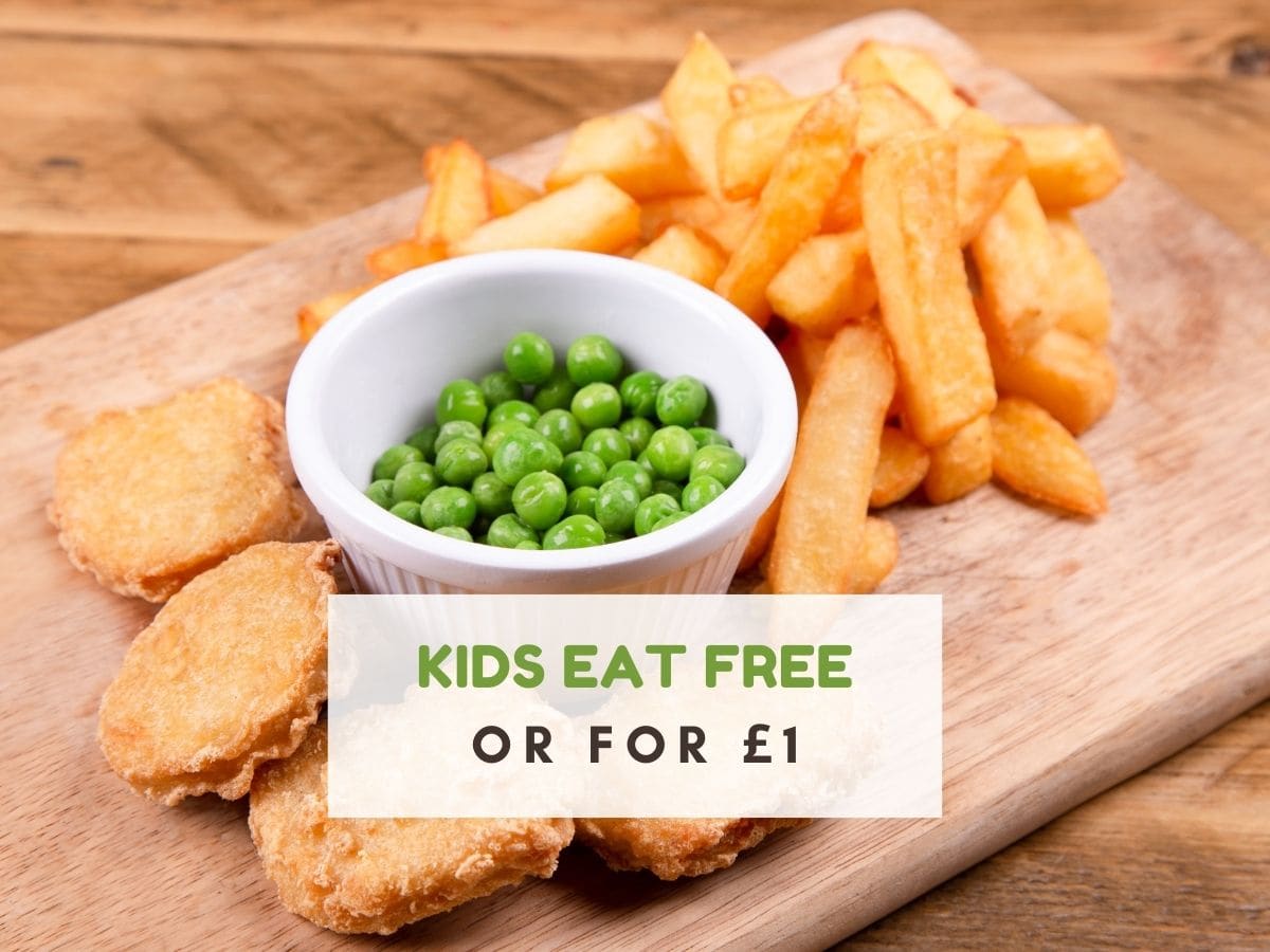Wooden board with chips, bowl of peas and chicken nuggets. Text reads kids eat free or for £1